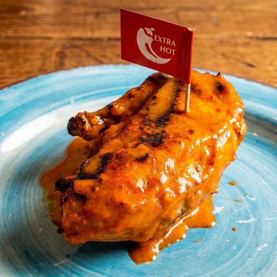 Extra hot chicken wings on a blue plate, with a red flag indicating "Extra Hot".