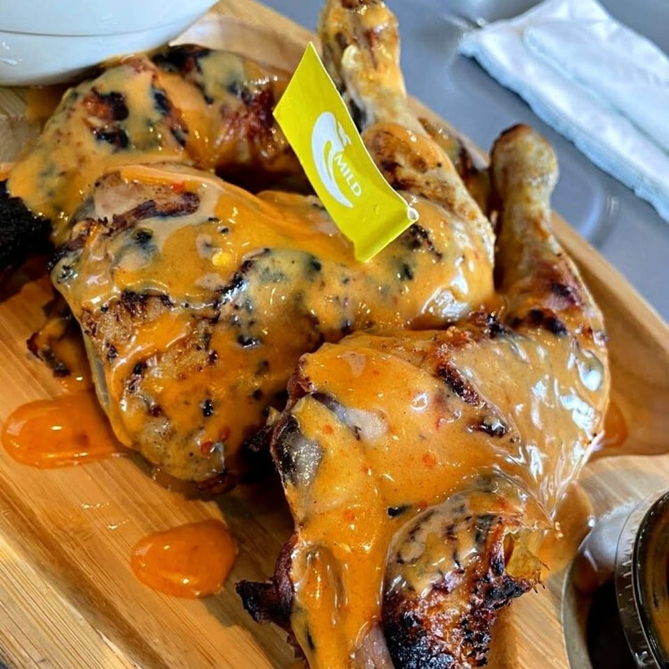 Grilled chicken pieces covered in creamy orange sauce, with a "MILD" flag.